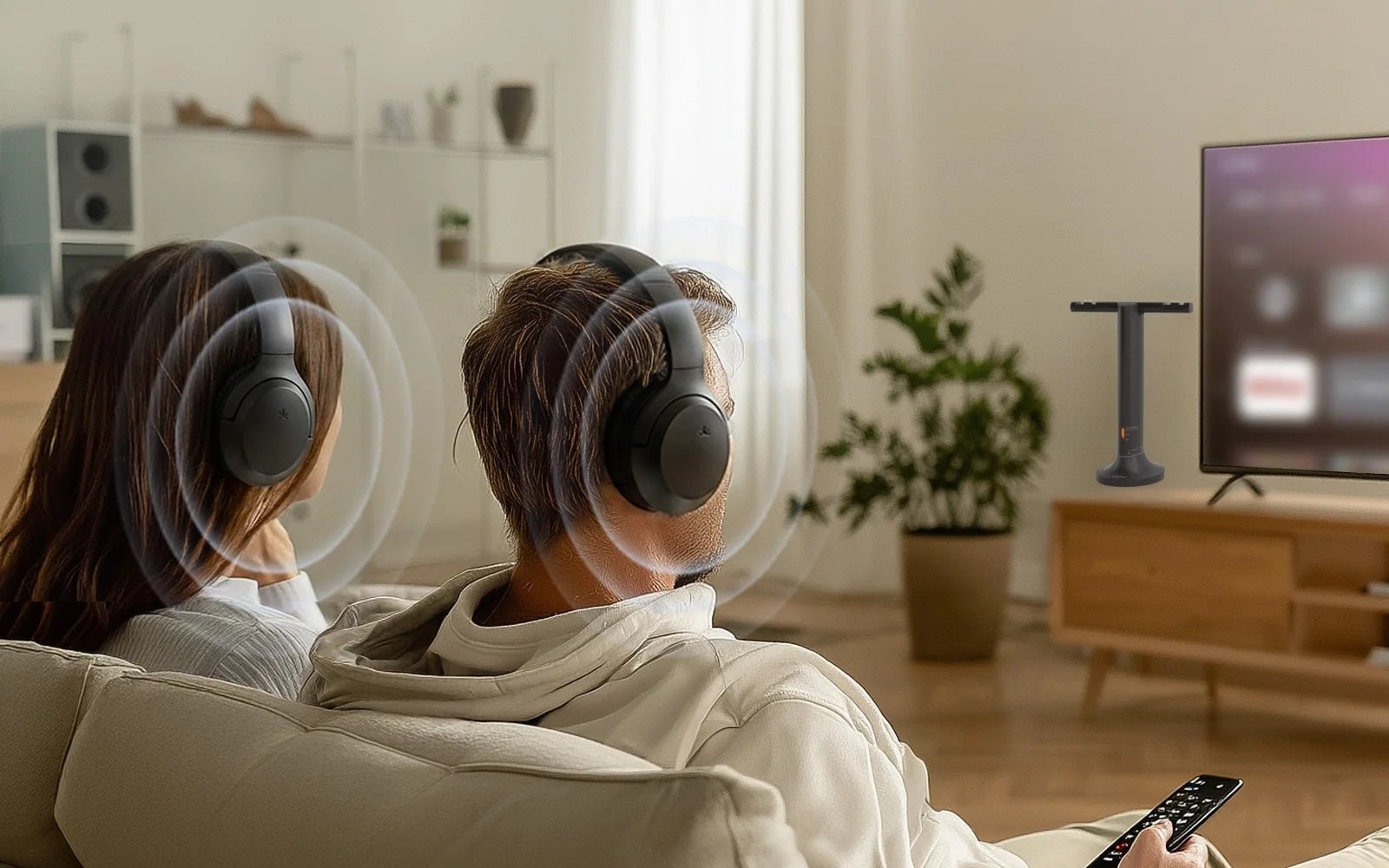 Two people sharing TV audio through wireless headphones