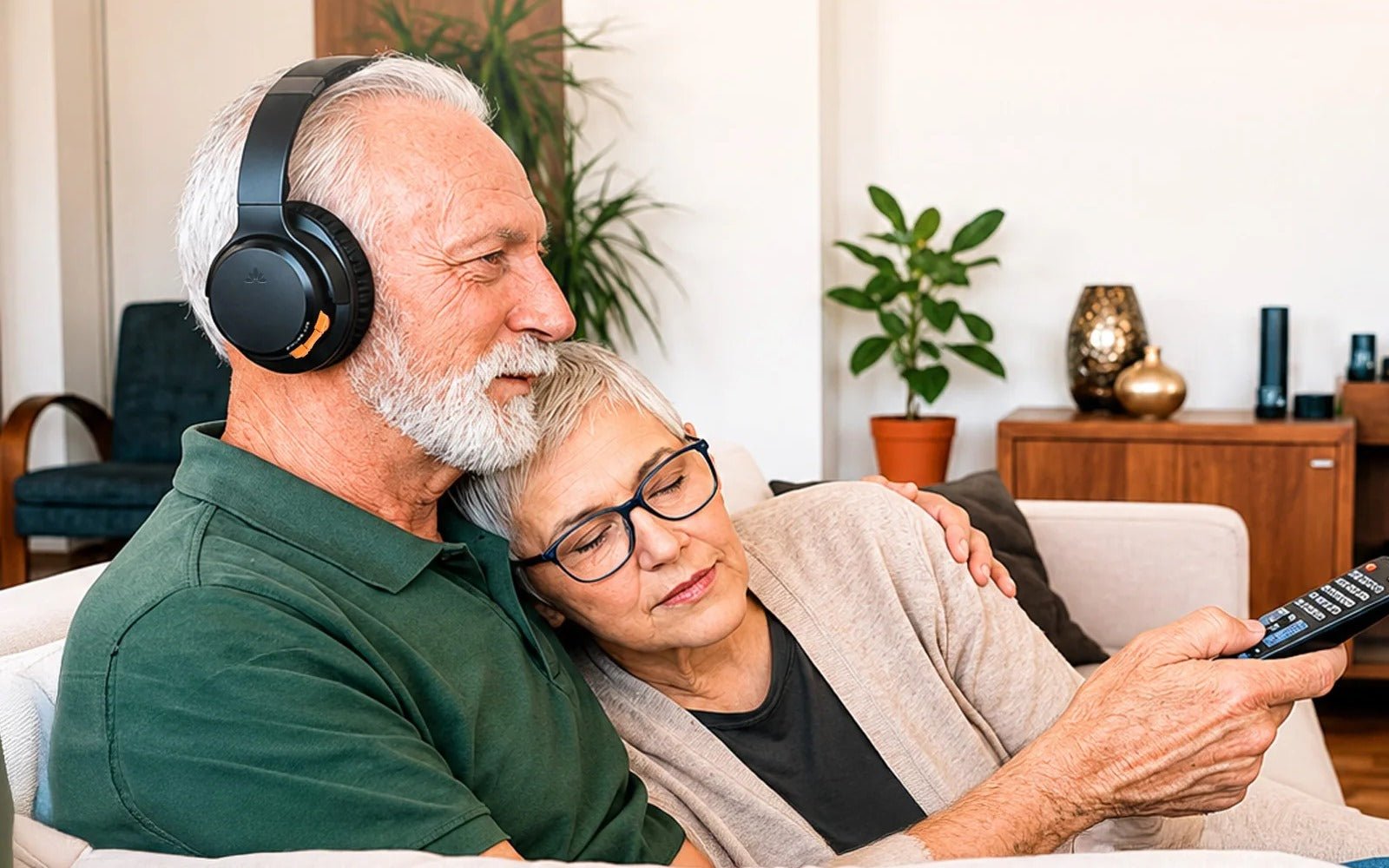 Man wearing TV headphones while watching TV with family nearby